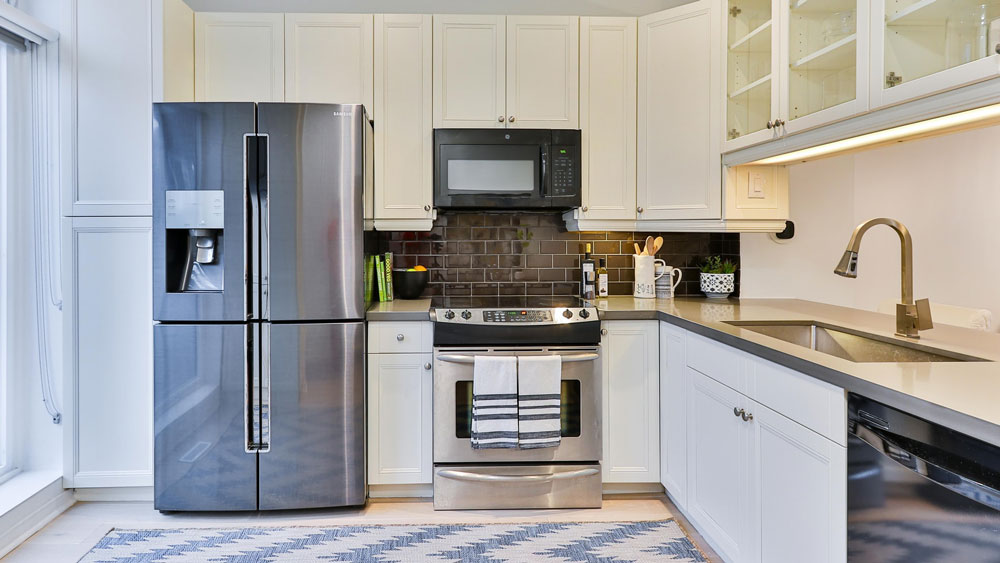 Kitchen with a refrigerator, oven, microwave, dishwasher and sink